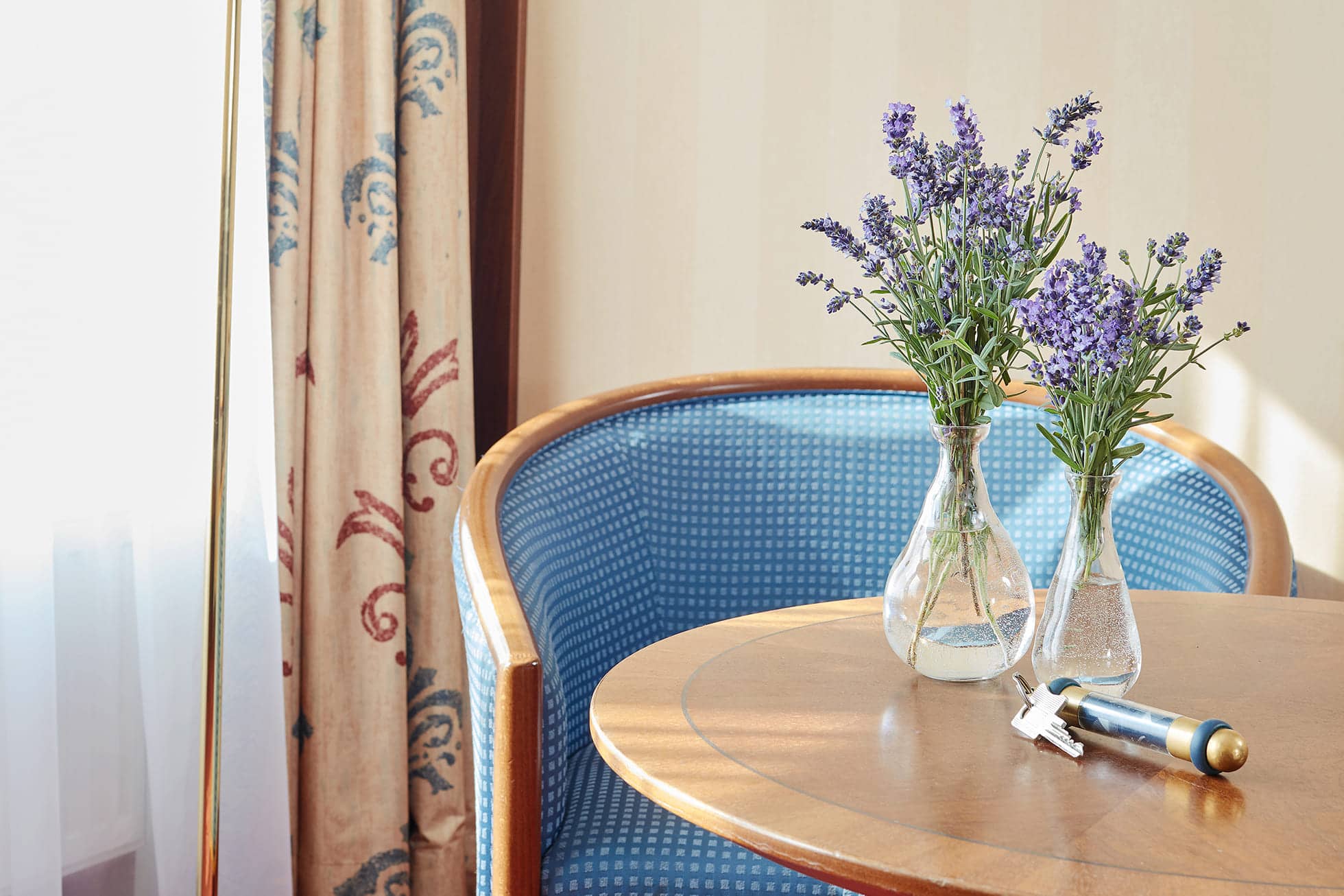Living Hotel Berlin Mitte Dreibettzimmer Sitzecke Sitzecke mit Blumen auf dem Tisch