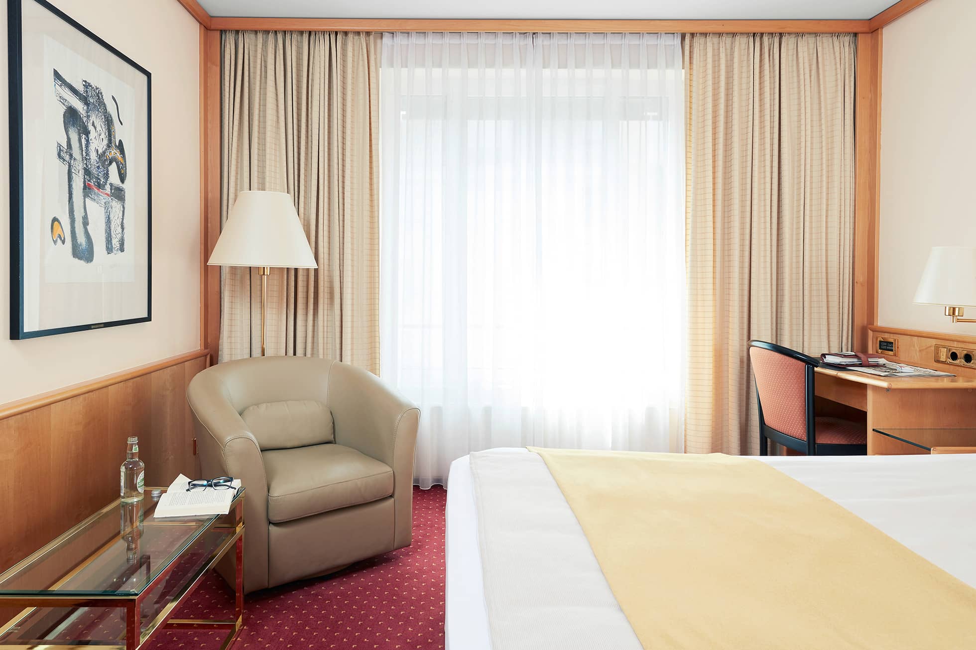 Living Hotel Grosser Kurfürst Superior Suite Schlafbereich Sessel mit Leselampe vor dem Fenster, davor Doppelbett