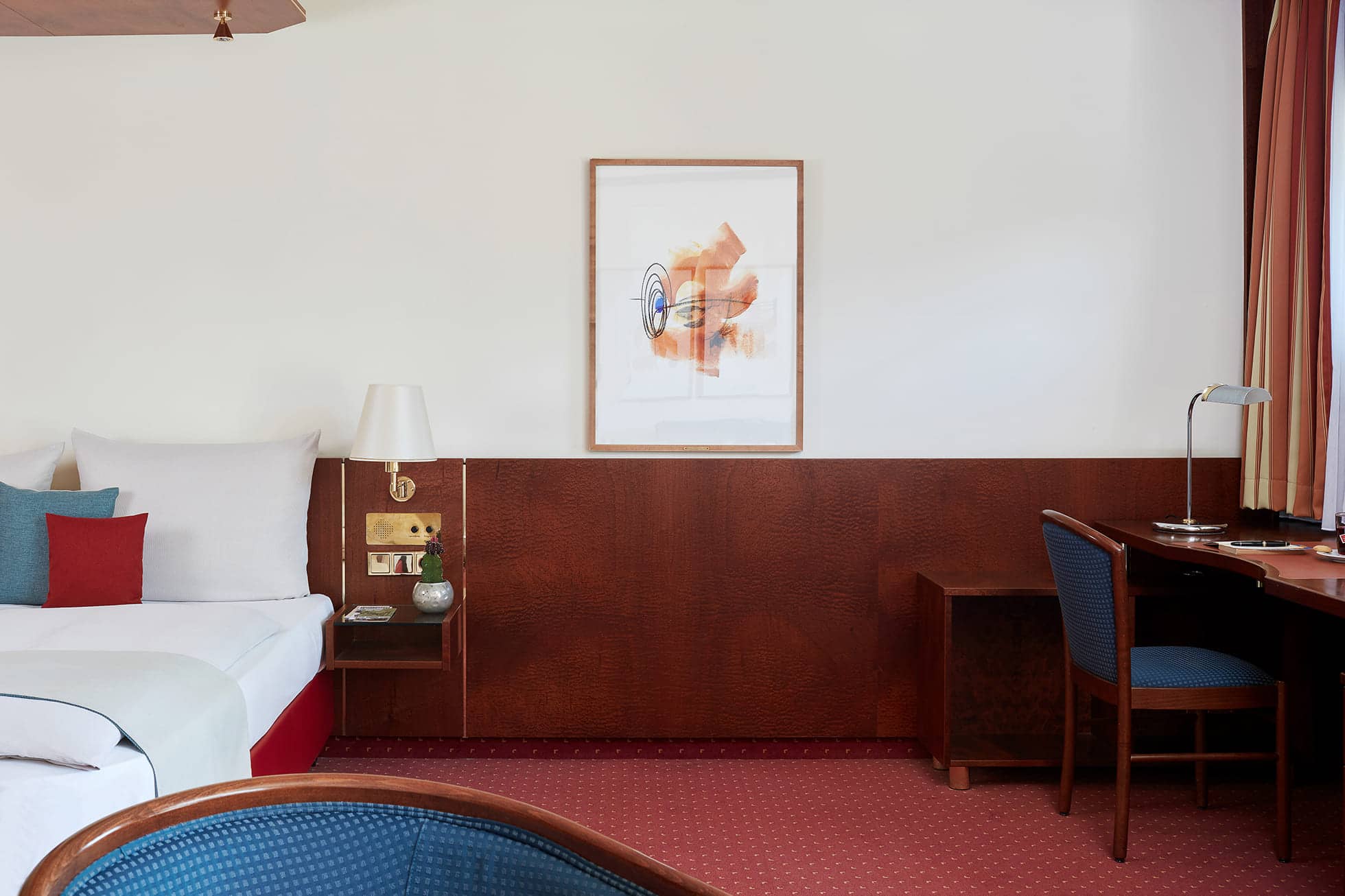 Living Hotel Weissensee Business Plus Apartment Bett und Schreibtisch im Hotelzimmer