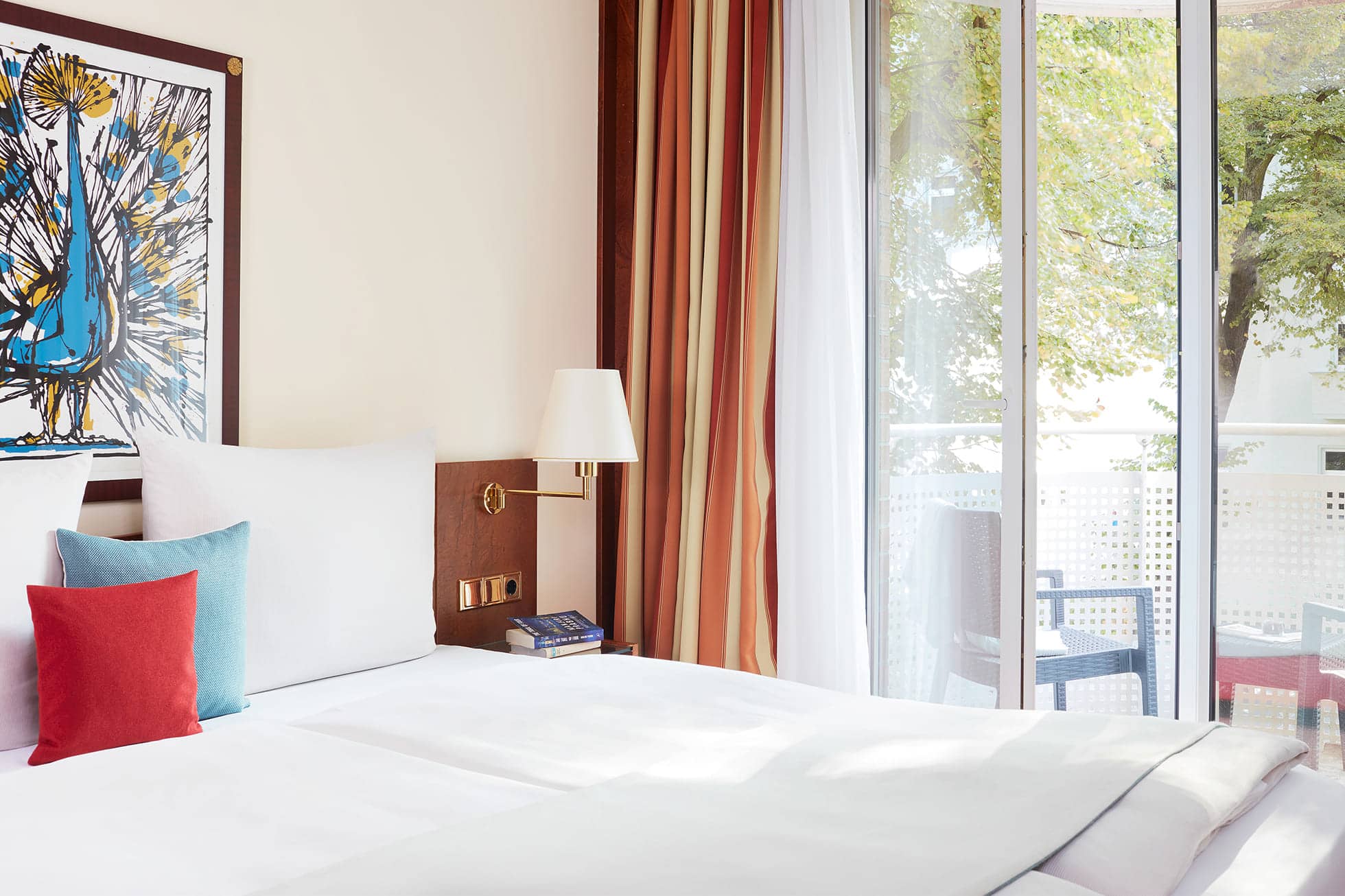 Living Hotel Weissensee Superior Maisonette Doppelbett Ansicht aufs Doppelbett und den Balkon in der Superior Maisonette
