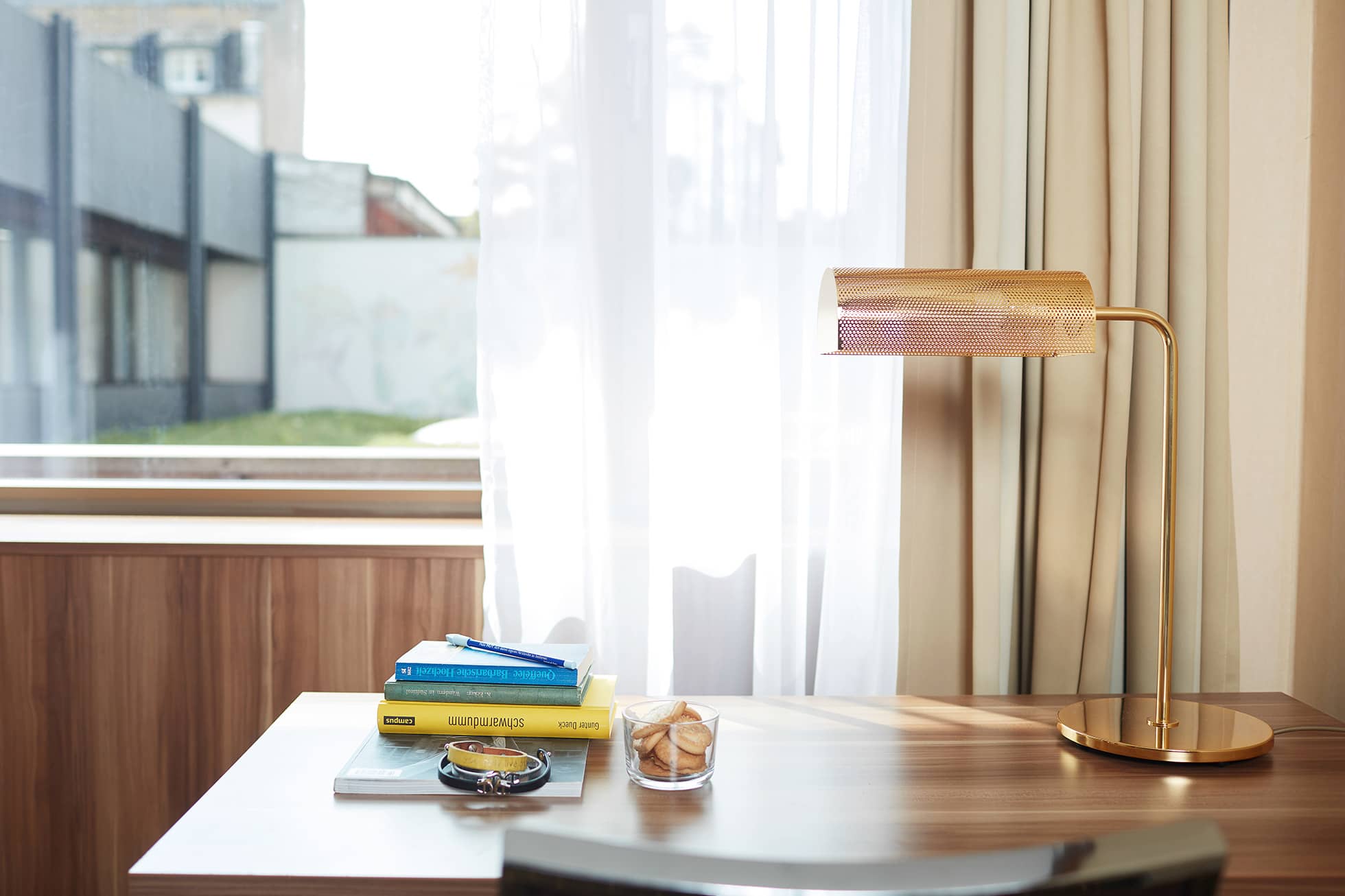 Living Hotel Düsseldorf Einzelzimmer Arbeitsbereich Bild Schreibtisch mit Lampe vor einem Fenster