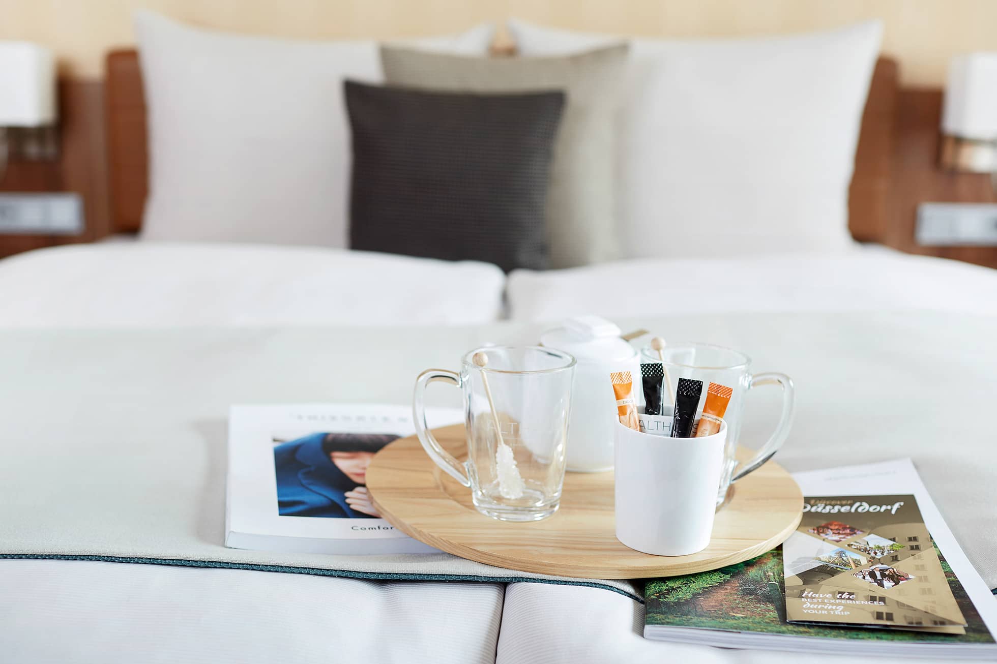 Living Hotel Düsseldorf Business Plus Doppelbett Doppelbett und Kaffee im Hotelzimmer