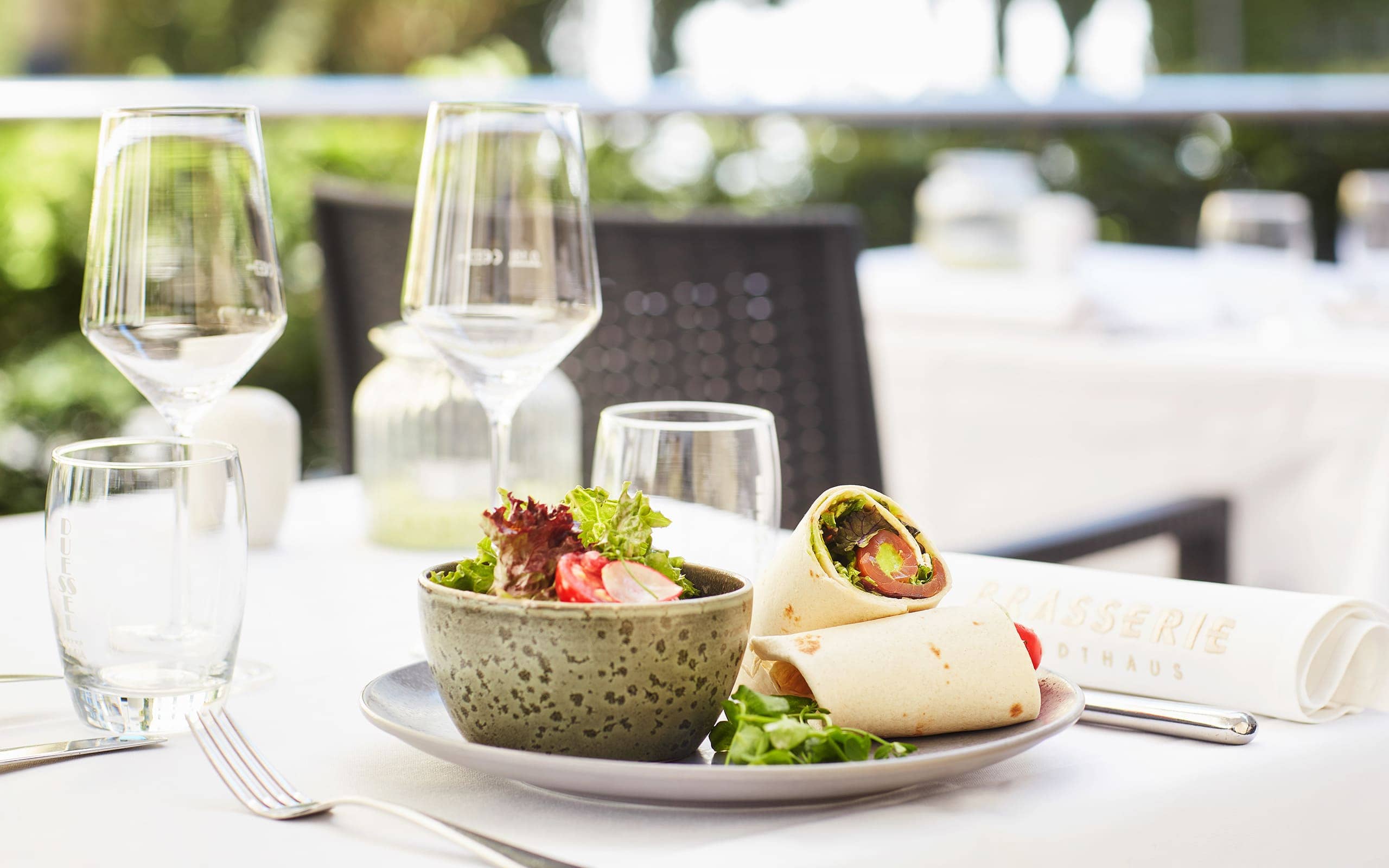 Brasserie im Living Hotel De Medici Gedeckter Tisch mit Wraps und Salat