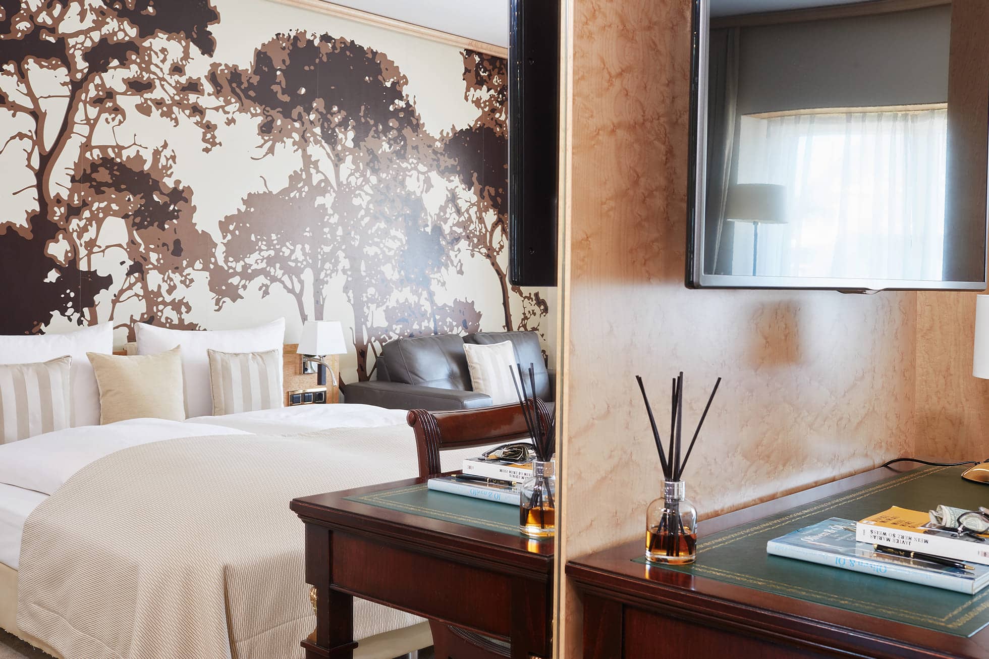 Living Hotel De Medici Deluxe Schlaf- und Arbeitsbereich Schreibtisch und die Spiegelung eines Doppelbetts