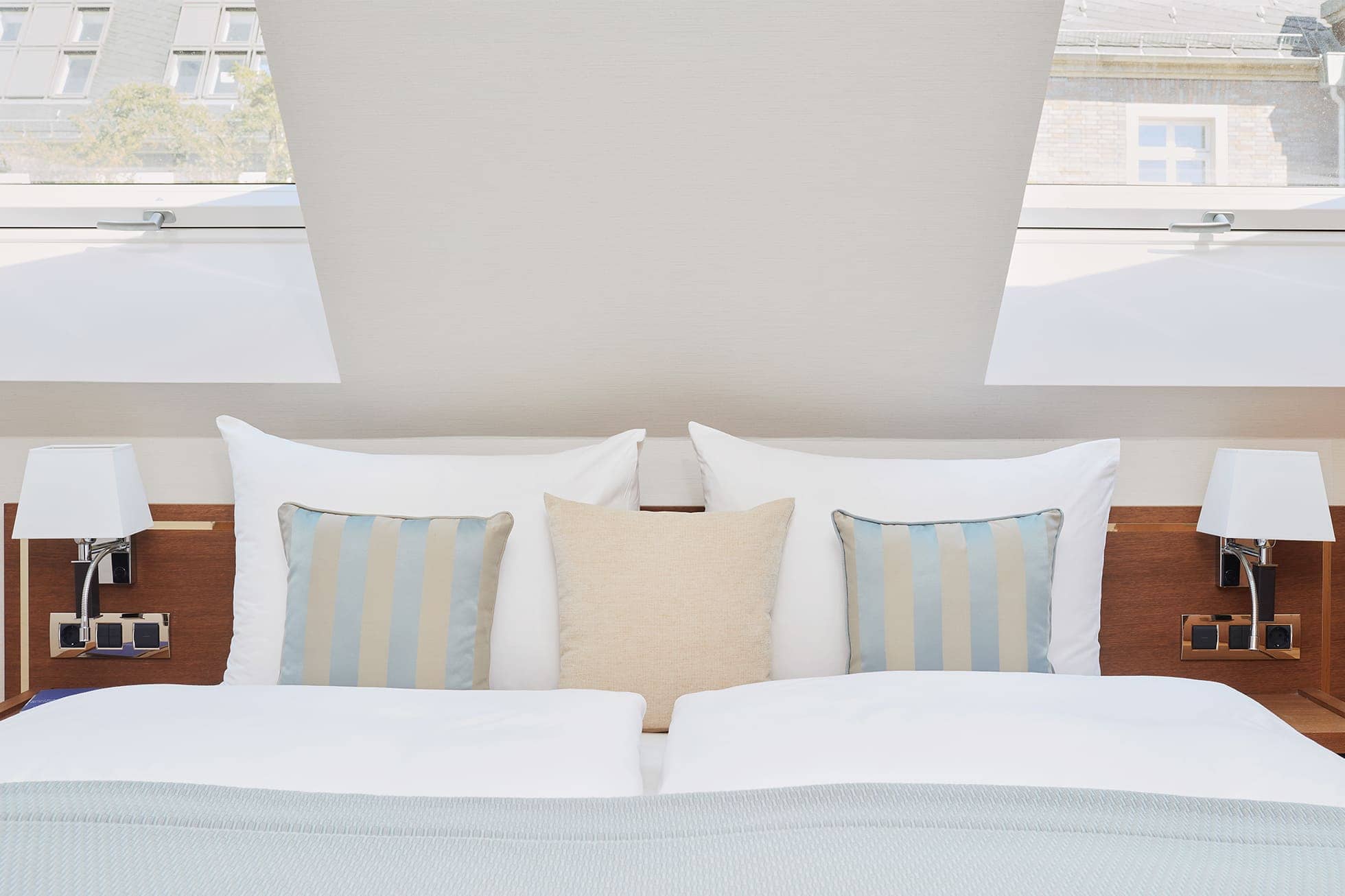 Living Hotel De Medici Turm Suite Bett Frontblick aufs Bett mit zwei Dachfenstern