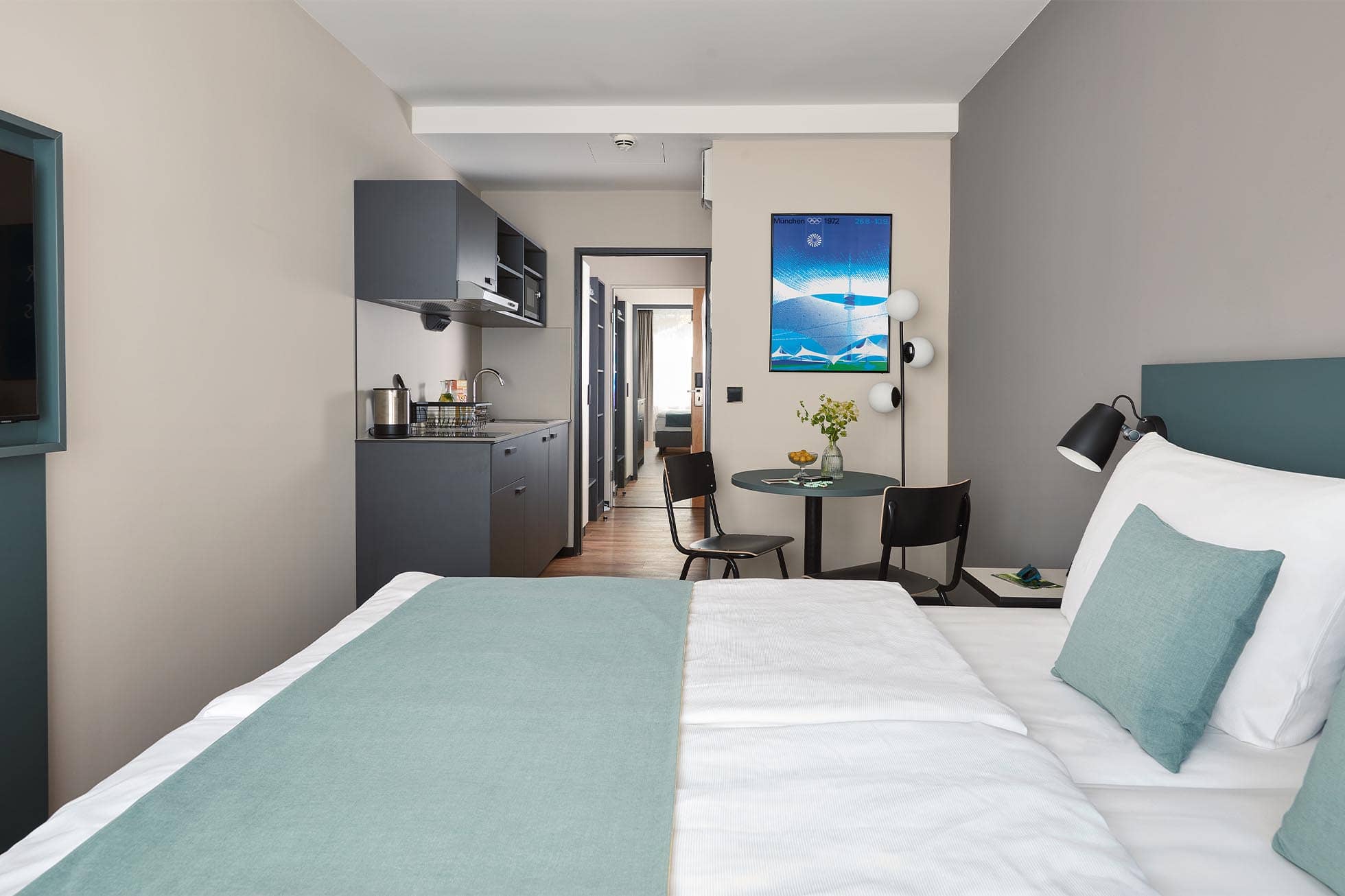 Deluxe Plus Doppel Apartment Blick vom Bett auf die Kitchenette und den Esstisch