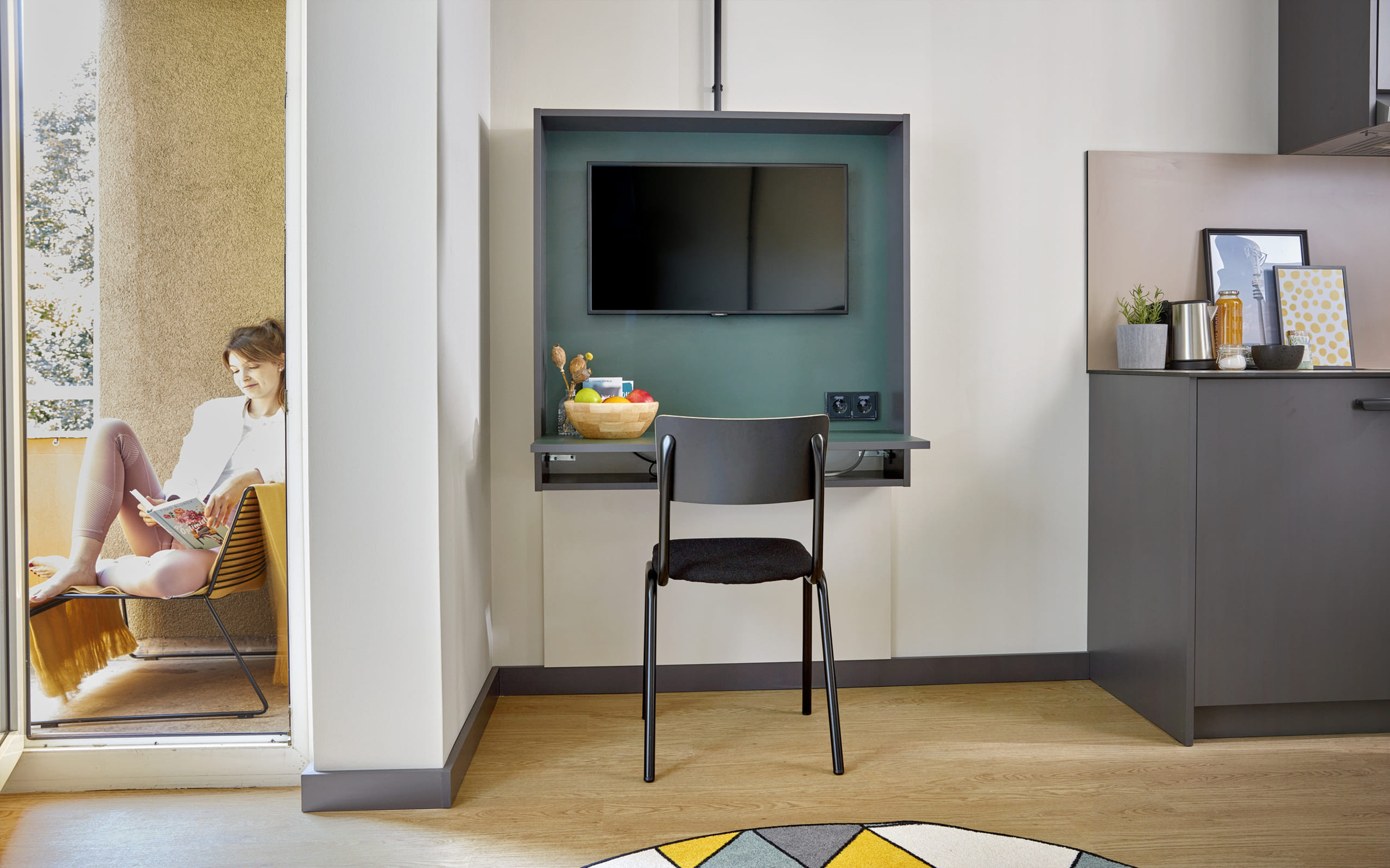 Balkon Living Hotels Ausschnitt des Zimmers mit Blick auf den Balkon, dem Schreibtisch und die Kitchenette