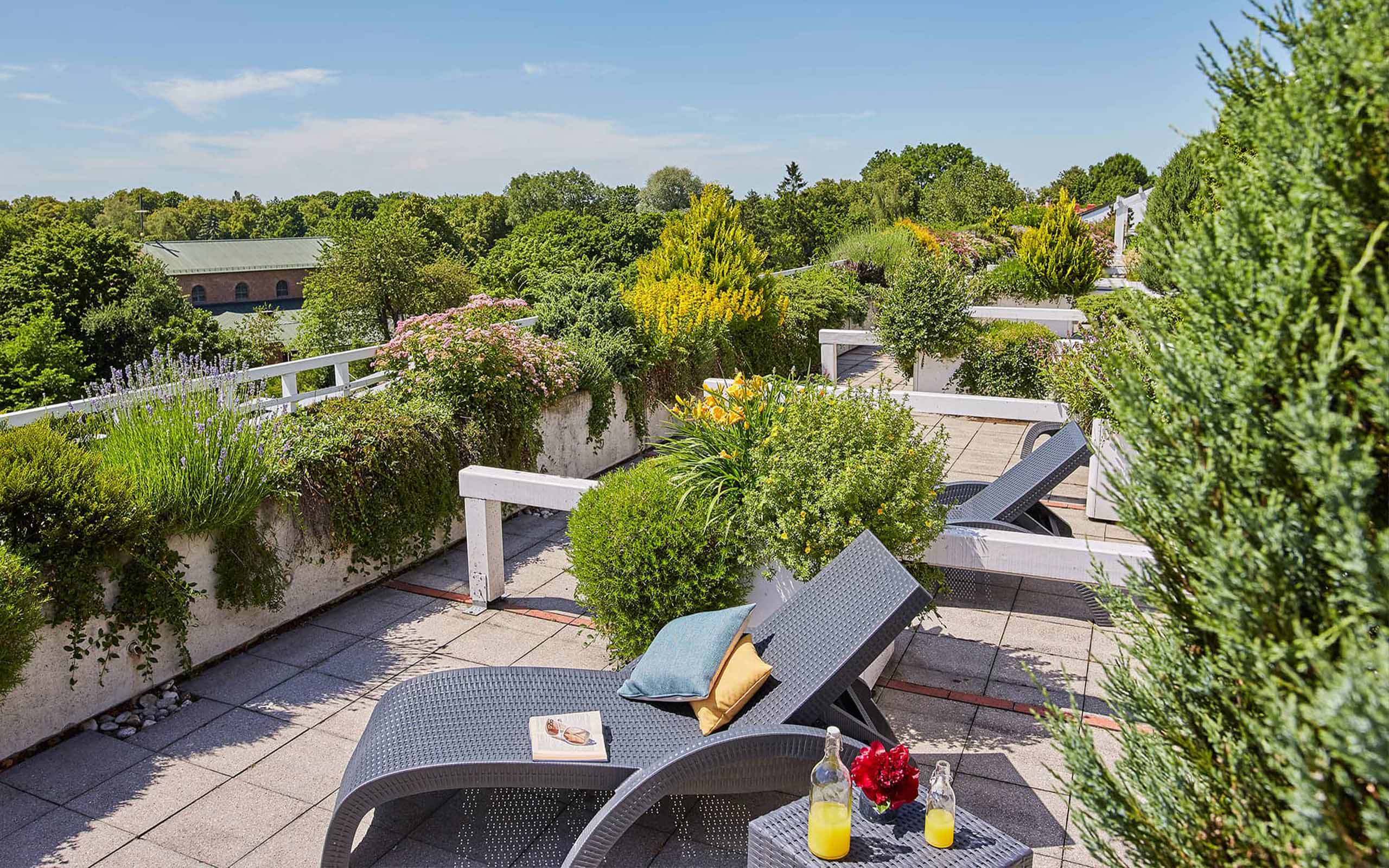 Grüner Balkon mit üppigen Pflanzen und gemütlichen Liegestühlen
