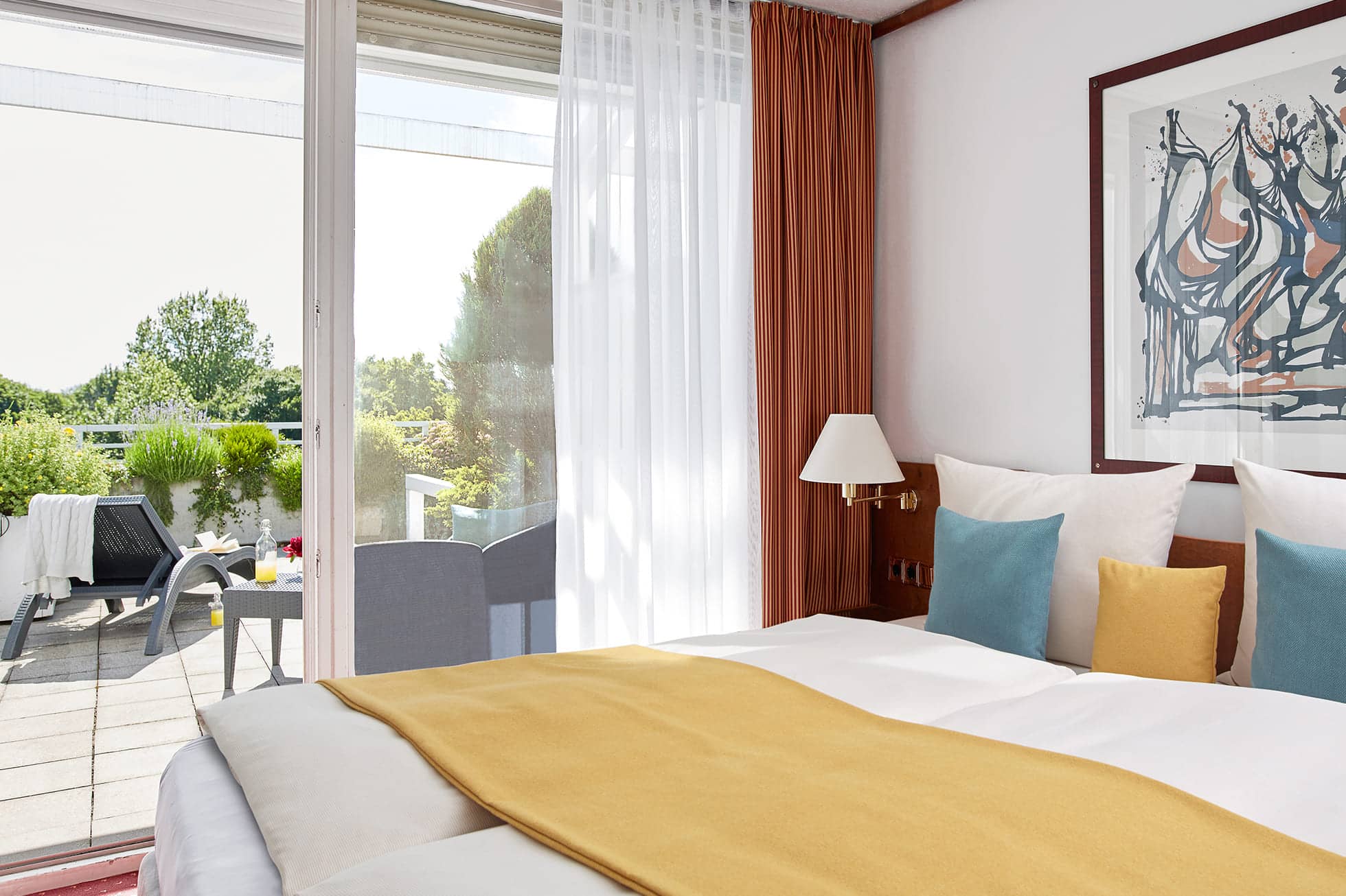 Living Hotel am Olympiapark Maisonette Bett Schlafzimmer mit Tür zum Balkon