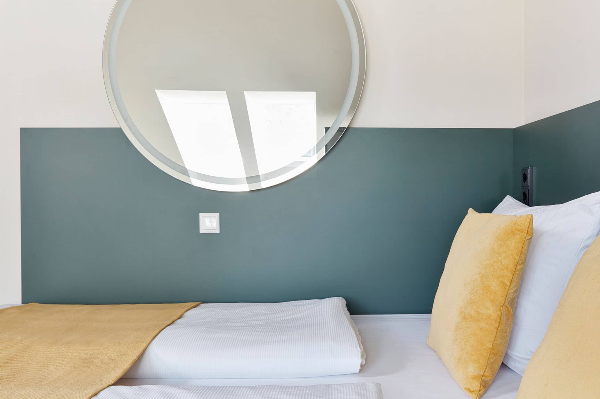 Living Hotel am Olympiapark Maisonette Deluxe Bett Bett und Spiegel im Aparthotel