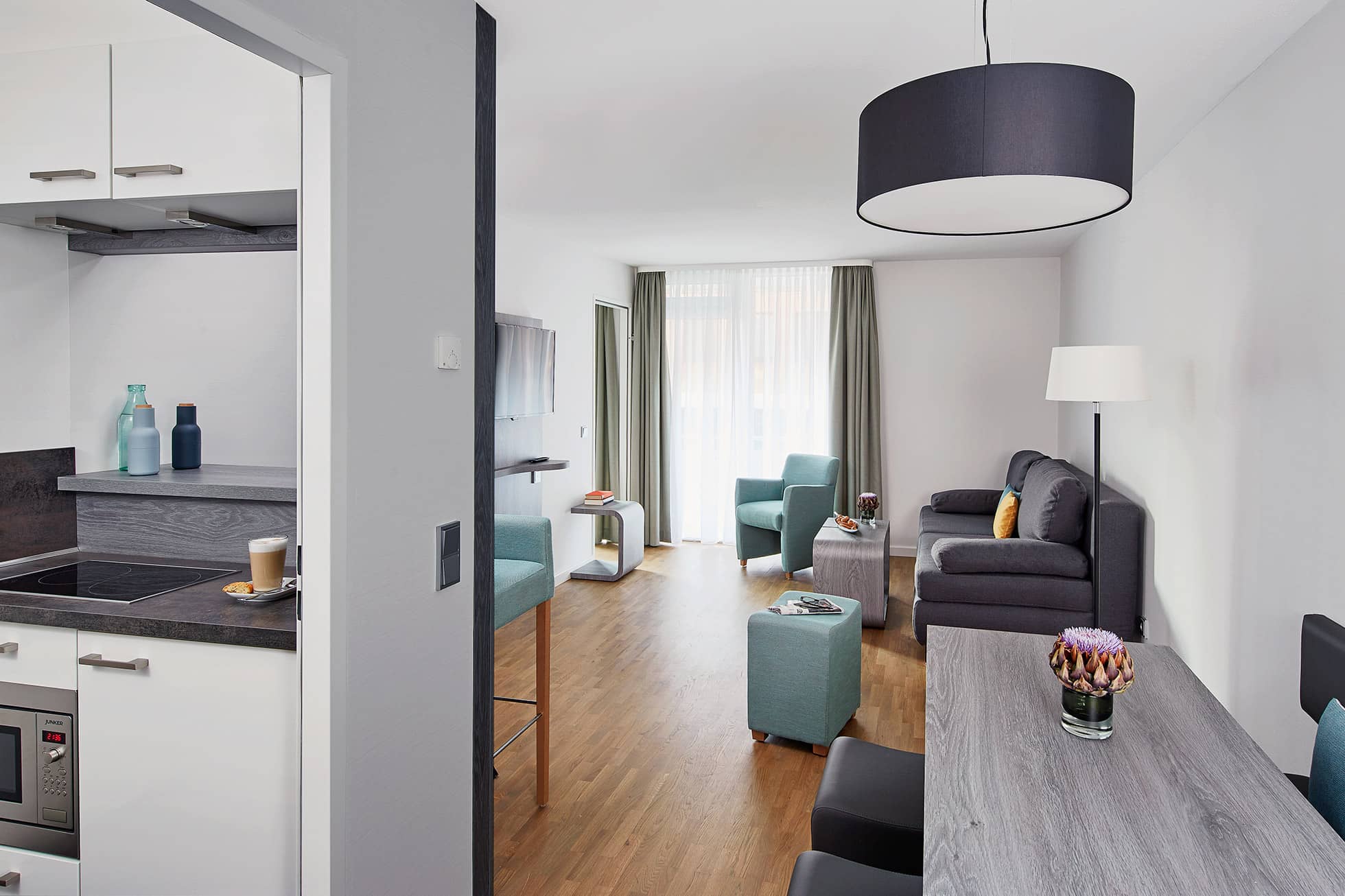 Living Hotel Nürnberg Superior Plus Zimmer Modernes Zimmer mit Fokus auf Küche und Essbereich