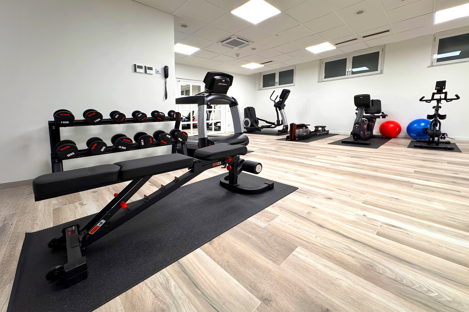 Fitness Raum verschiedene Hanteln und Hantelbank im Fitness Raum