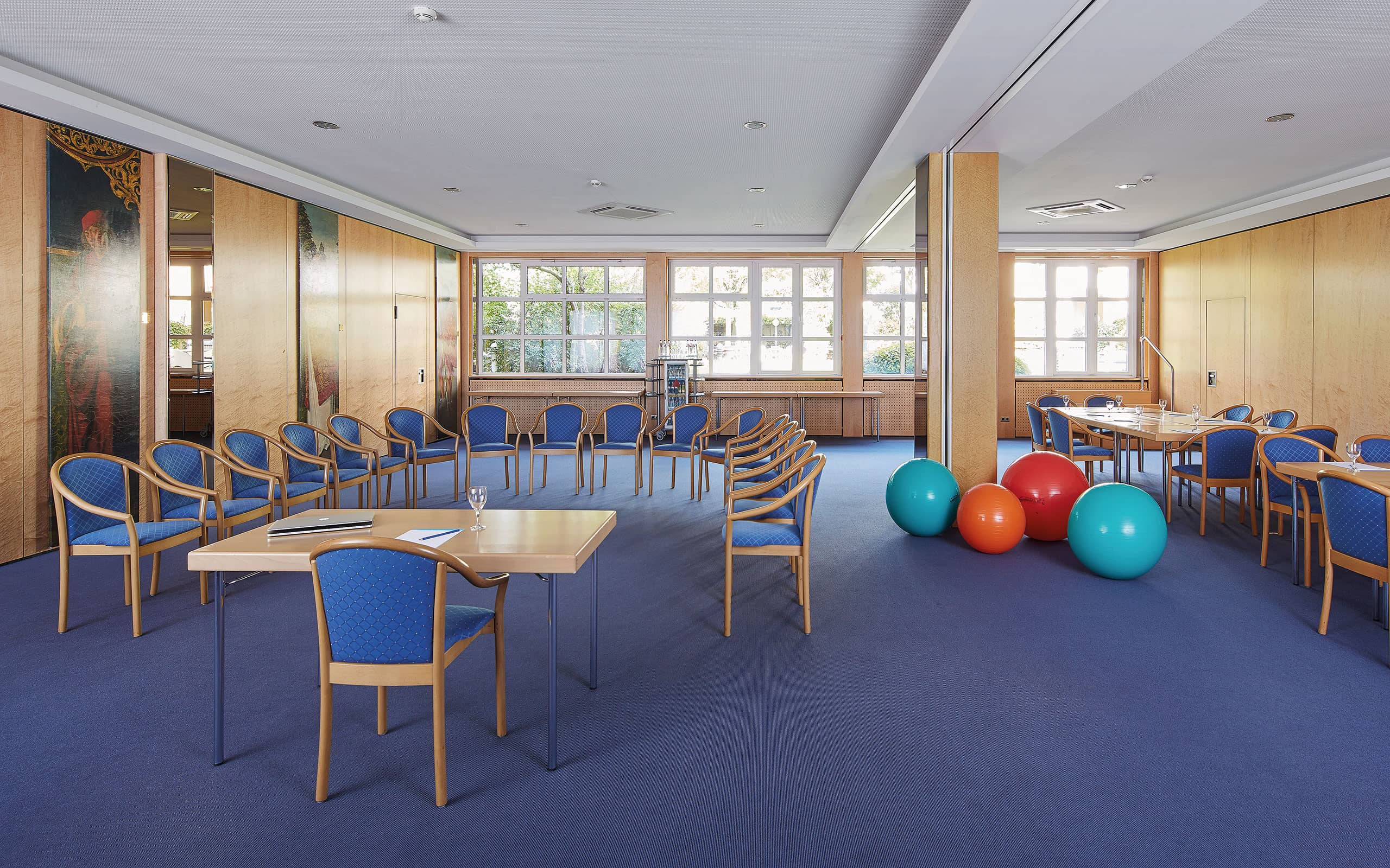 großer Tagungsraum mit großem Tisch und vielen Stühlen und Gymnastikbällen